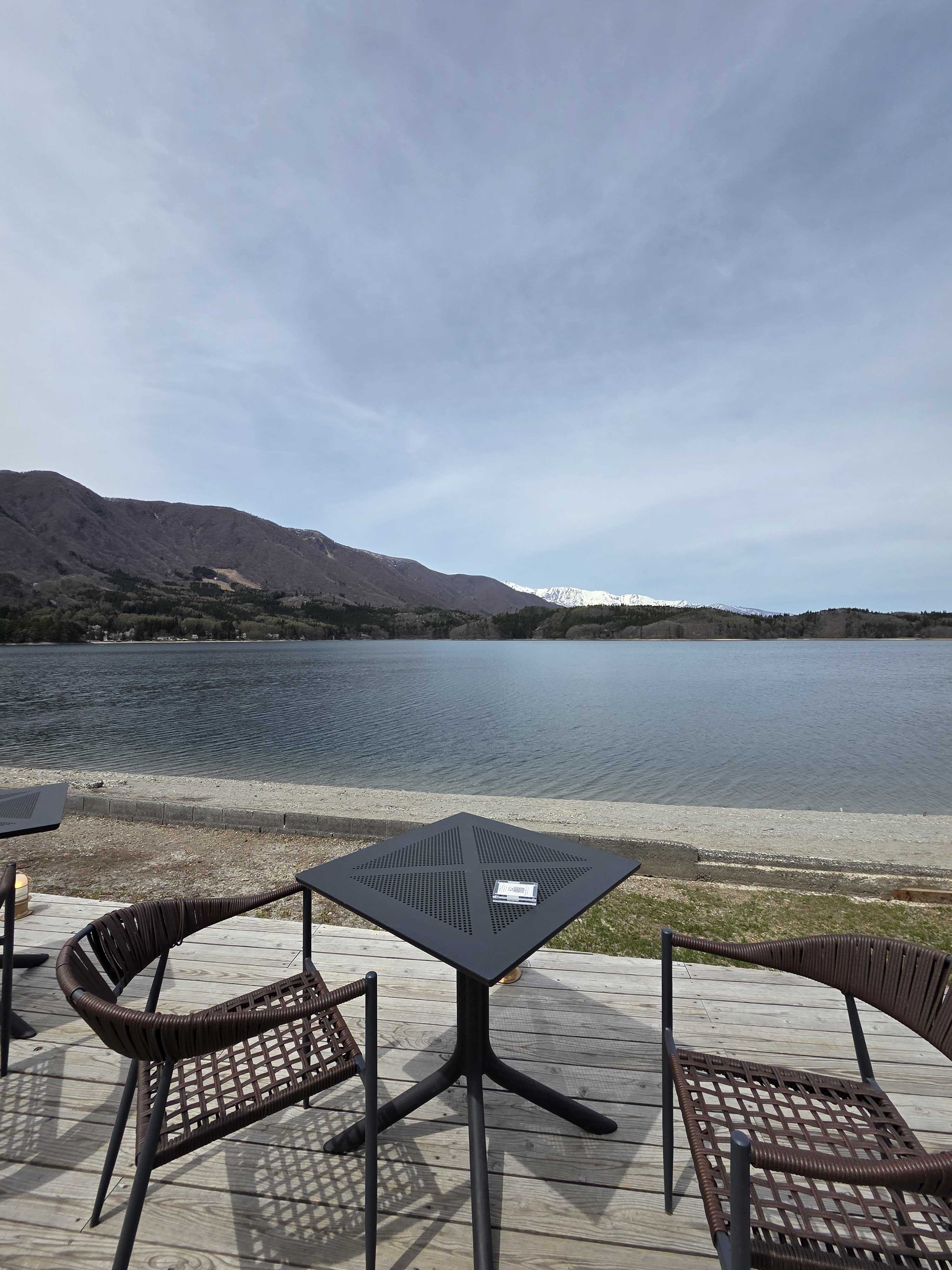 Terrace seating at ao LAKESIDE CAFE overlooking Lake Aoki with mountain views